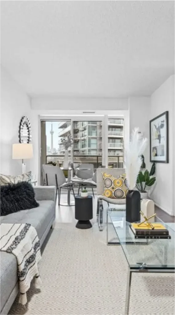 Stylish condo living room with balcony view and glimpse of CN Tower in Liberty Village Toronto.